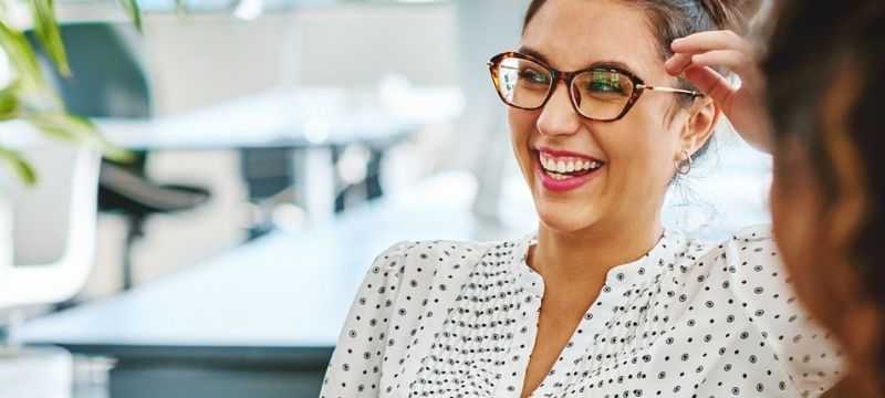 Businesswoman laughing with colleagues.