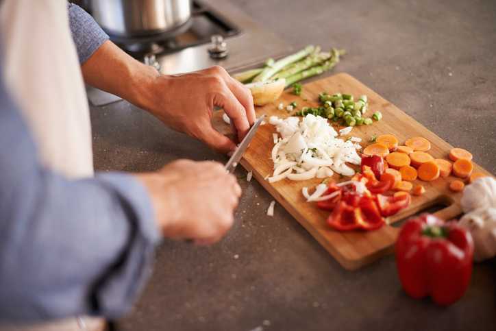 Cropped shot of a man chopping vegetables on a countertop